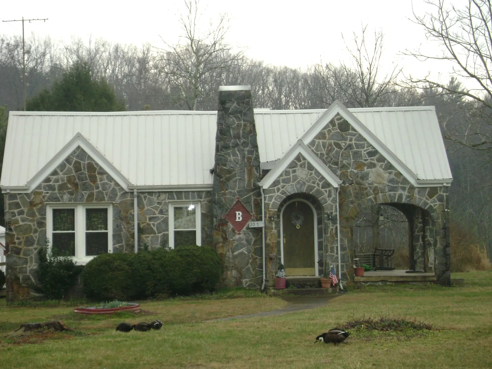 White metal roof on a stone cottage with steep gables in Wappingers Falls