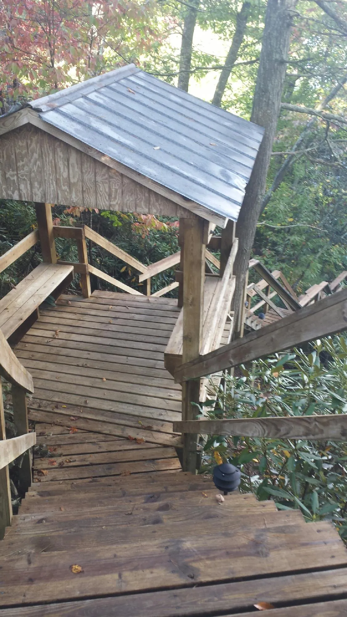 Metal roofed shelter over wooden steps on a wooded walkway — Skylight Repair & Installation work by our crew in Wappingers Falls